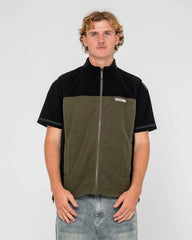 Man wearing a black and green two-tone jacket on a plain background