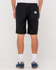 Person wearing black shorts with a small logo on a white background