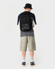 Person wearing a black backpack with a visible brand logo on a white background