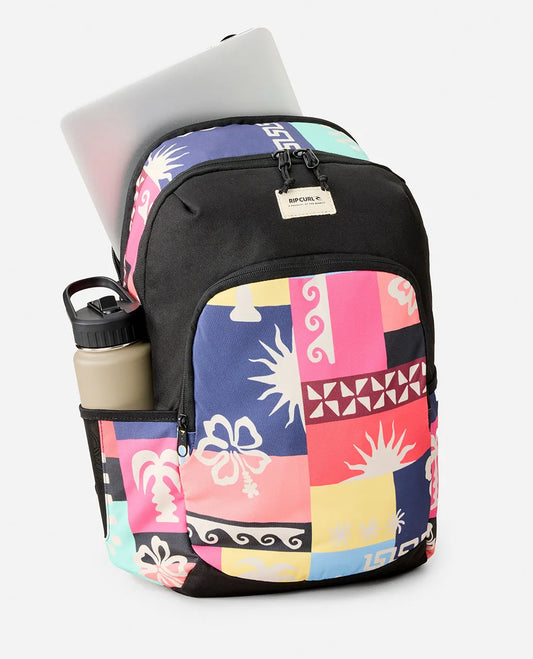 Colorful patterned backpack with laptop and water bottle on a white background