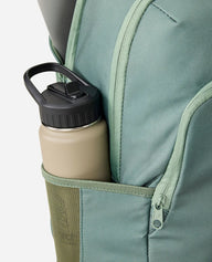 Beige water bottle with black lid in a green backpack pocket