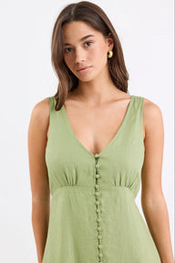 Woman wearing a green dress with a plain background