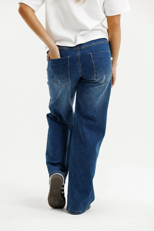 Person wearing blue jeans and a white shirt on a white background