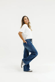Woman wearing a white t-shirt and blue jeans on a white background
