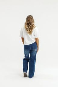 Person wearing a white shirt and blue jeans on a white background
