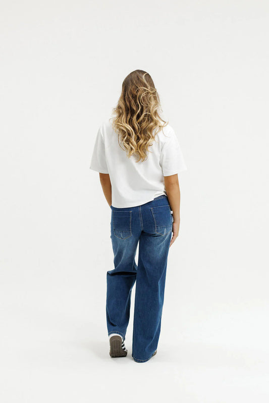 Person wearing a white shirt and blue jeans on a white background