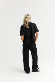 Person wearing a black outfit on a white background