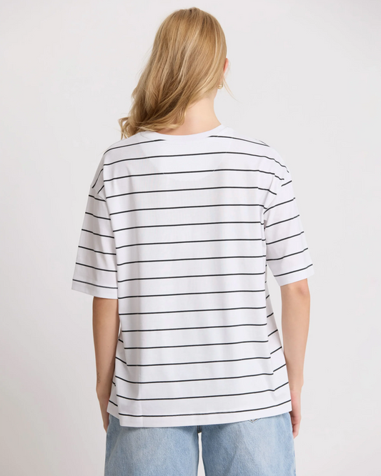 Person wearing a white t-shirt with black stripes on a plain background