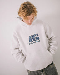 Person wearing a white hoodie with a logo and text on a plain background