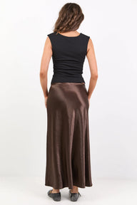 Woman wearing a black top and brown skirt on a white background
