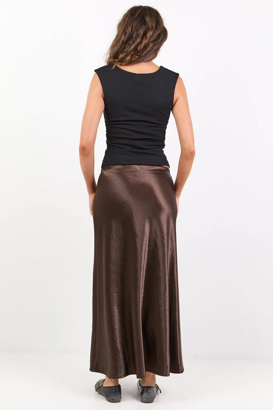 Woman wearing a black top and brown skirt on a white background