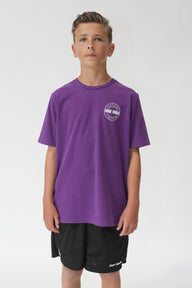 Young person wearing a purple t-shirt with a logo on a white background