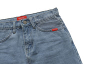 Close-up of blue denim skirt with red labels on a white background