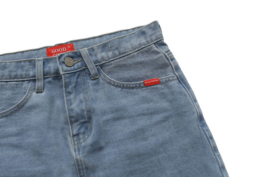 Close-up of blue denim skirt with red labels on a white background