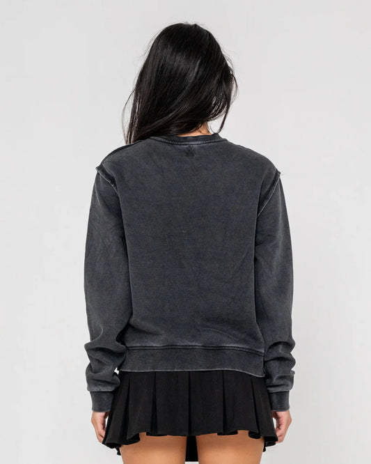 Person wearing a dark gray sweatshirt and black skirt on a light gray background
