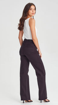 Woman wearing a white top and black high-waisted pants on a light gray background