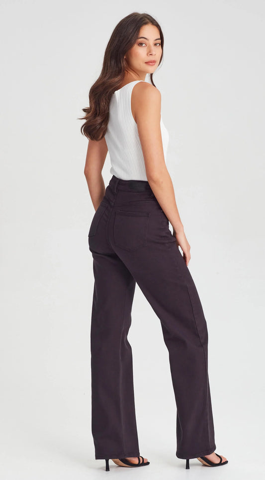 Woman wearing a white top and black high-waisted pants on a light gray background