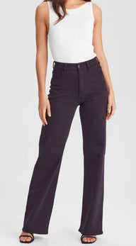 Person wearing black jeans and a white top on a white background