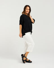 Lady in Black Nikita Top with White 3/4 pants and a white background