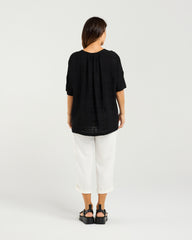 Lady in Black Nikita Top with White 3/4 pants and a white background