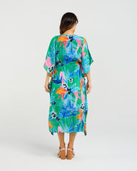 Woman wearing the Seduce Sonya Dress a colorful floral dress on a white background  