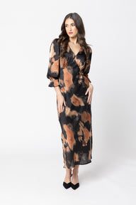 Woman wearing a long, patterned dress on a white background
