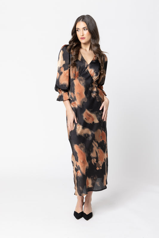 Woman wearing a long, patterned dress on a white background