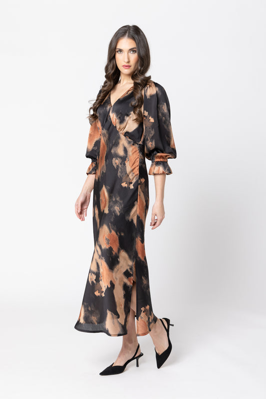 Woman wearing a long, patterned dress on a white background
