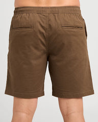 Brown elastic-waist shorts with two rear welt pockets, shown on a model from the back against a light gray background.