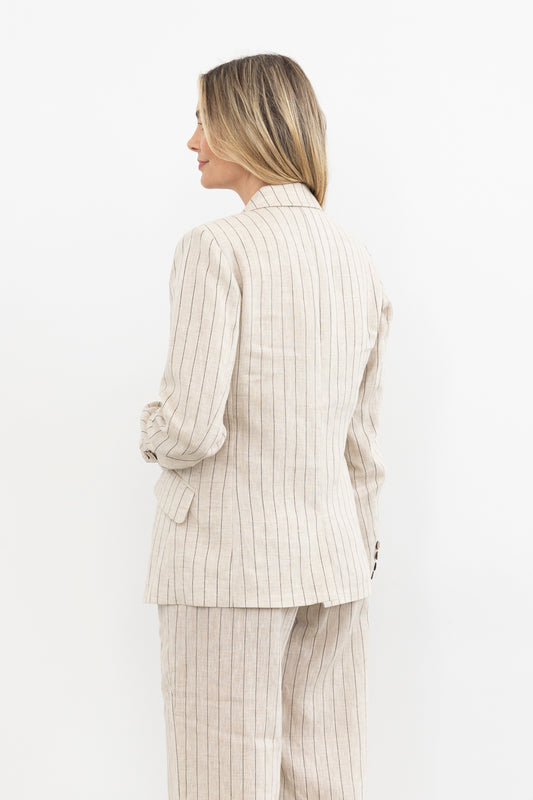 Woman wearing a beige pinstripe suit against a white background