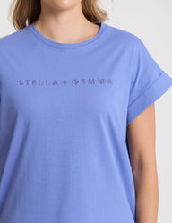 Blue t-shirt with 'Stella + Gemma' logo worn by a person on a white background