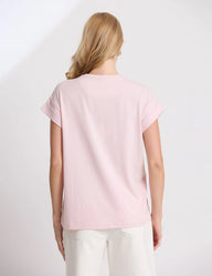 Woman wearing a light pink t-shirt against a white background