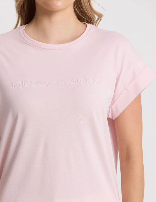Pink t-shirt with 'Stella McCartney' logo worn by a person on a white background