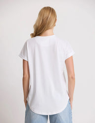 Person wearing a white t-shirt and light blue jeans on a plain background