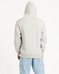 Person wearing a light gray hoodie and light blue jeans on a white background
