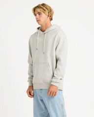 Person wearing a gray hoodie and light blue jeans on a white background