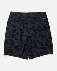 Black and dark gray camouflage cargo shorts shown from the back, featuring a small white logo patch on the upper right side, photographed on a light gray background.
