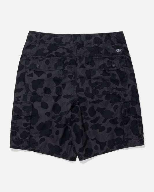 Black and dark gray camouflage cargo shorts shown from the back, featuring a small white logo patch on the upper right side, photographed on a light gray background.