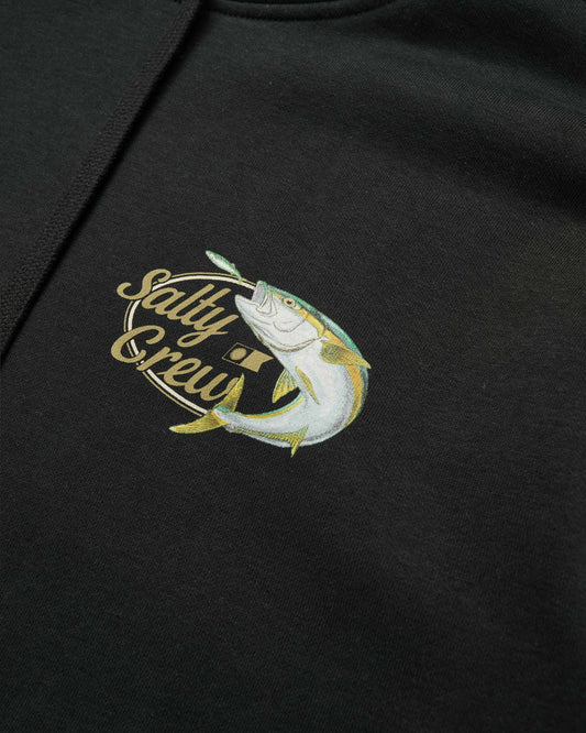 Close-up of a black hoodie featuring a colorful embroidered graphic on the chest. The design shows a silver and yellow fish jumping out of a gold oval frame with the text 'Salty Crew' written in gold script.