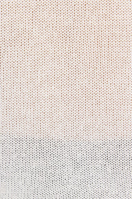 Close-up of a textured knit fabric with a vertical color-blocked pattern, transitioning from a warm cream and light brown top section to a white bottom section.