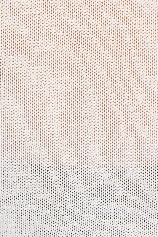 Close-up of a textured knit fabric with a vertical color-blocked pattern, transitioning from a warm cream and light brown top section to a white bottom section.