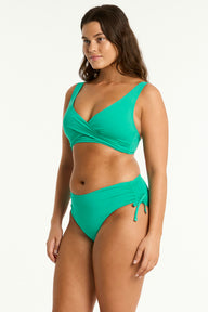 Woman wearing a green bikini set on a white background