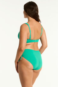 Woman wearing a green bikini set on a white background