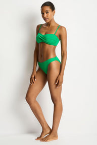 Woman wearing a green bikini against a white background