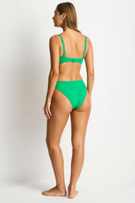 Woman wearing a green bikini on a white background