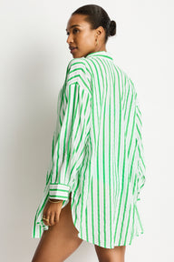 Woman wearing a green and white striped shirt against a plain background