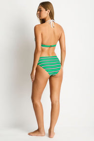 Woman wearing a green and white striped bikini on a white background