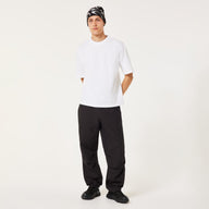 Person wearing a white t-shirt, black pants, and a patterned beanie on a white background