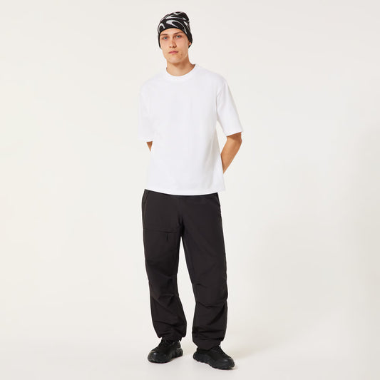 Person wearing a white t-shirt, black pants, and a patterned beanie on a white background