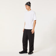 Person wearing a white t-shirt, black pants, and a patterned beanie on a white background
